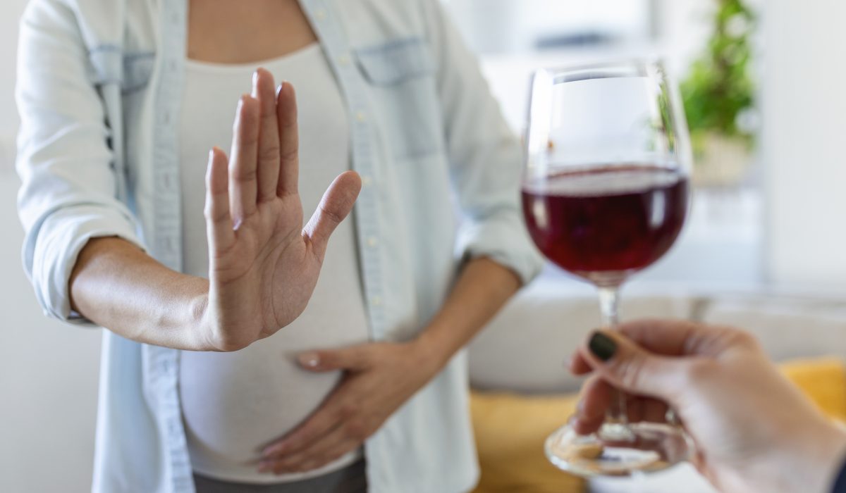 Pregnant woman refusing a glass of wine. Alcohol In Pregnancy. Unrecognizable Expectant Lady Gestring Stop To Offered Glass Of Wine